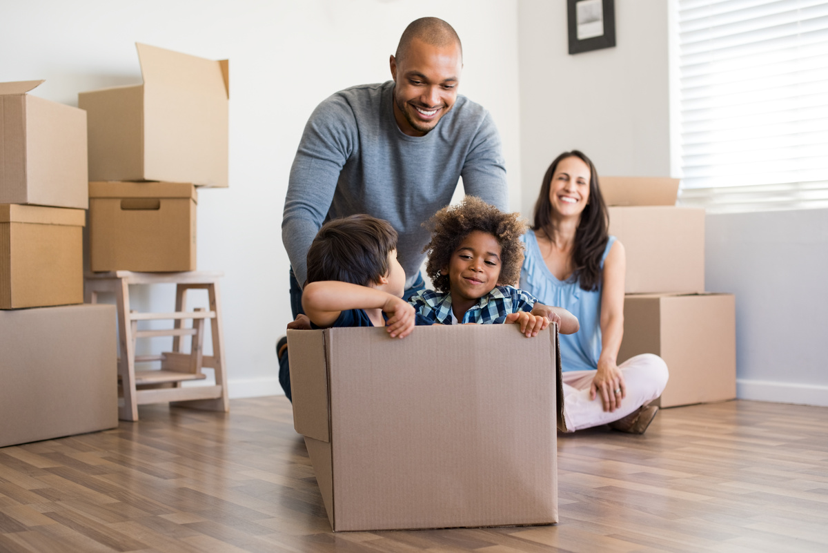 Famille en cours de déménagement enfants jouer cartons